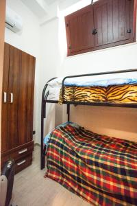 a bedroom with a bunk bed with a checkered blanket at Apartment Eutime- in Locri