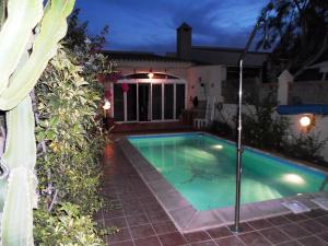 a swimming pool in front of a house at night at Lovely CottageAurora in Corralejo