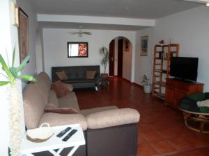 un soggiorno con un divano e una TV di Lovely CottageAurora with Wi-fi and Private-pool a Corralejo