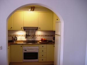 an archway in a kitchen with a stove and refrigerator at Lovely CottageAurora in Corralejo