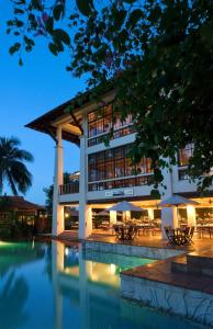 a hotel with a swimming pool in front of a building at Avillion Port Dickson in Port Dickson