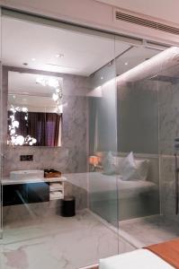a bathroom with a glass shower and a sink at Signature Boutique Hotel in Ho Chi Minh City