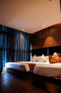 a bedroom with two beds and a large window at Signature Boutique Hotel in Ho Chi Minh City