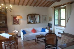 a living room with a white couch and a table at Silence and relaxation in the woods of Umbria in Porchiano