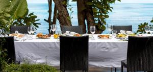 a table with plates of food and wine glasses at Sangsuri Villa 2 in Choeng Mon Beach