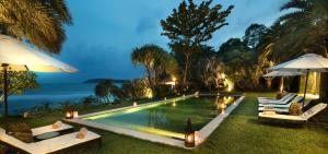 a swimming pool with chairs and umbrellas next to the water at Sangsuri Villa 2 in Choeng Mon Beach +18 photos