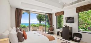 a bedroom with a large bed and large windows at Sangsuri Villa 2 in Choeng Mon Beach
