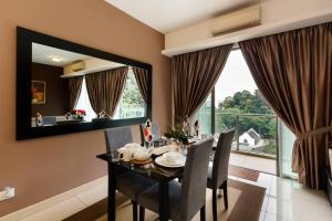 a dining room with a table and chairs and a large window at Cozy Spacious 2BR Bukit Bintang With Lush Greenery in Kuala Lumpur