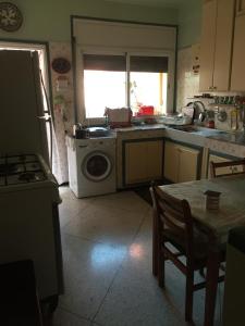 a kitchen with a washing machine and a table at Property located in a quiet area near the train station in Casablanca