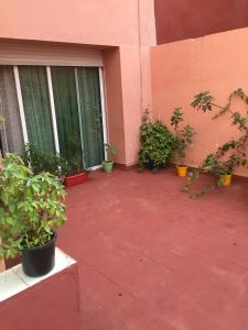 een patio met potplanten voor een gebouw bij Property located in a quiet area near the train station in Casablanca