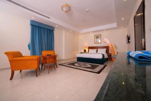 Habitación de hotel con cama, sofá y sillas en الجوهرة الأولى للوحدات السكنية - حي الحمدانية, en Yeda