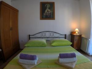 sypialnia z dużym zielonym łóżkiem z 2 poduszkami w obiekcie Antique apartment with balcony w mieście Stari Grad