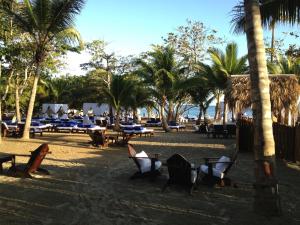 a beach with tables and chairs and palm trees at Junior Suite in Puerto Plata at Lifestyle Holidays Vacation Club in San Felipe de Puerto Plata