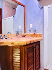a bathroom with a sink and a mirror at Sunrise Double Room in Stunning Villa Playacar Ii in Playa del Carmen
