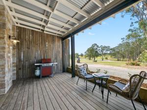 een terras met stoelen en een tafel en een bureau bij Block Eight Estate Vineyard View Villa in Belford