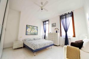 a white bedroom with a bed and a couch at SantaMarta, the apartment for your Venetian holidays in Venice