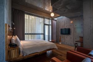 a bedroom with a large bed and a television at FaHaus in Checheng