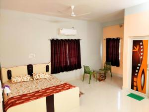 a bedroom with a bed and chairs in it at Zara Homestay Santiniketan in Shānti Niketan +42 photos