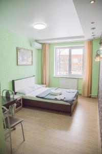 a bedroom with a bed and a desk and a window at Hotel Mir in Izhevsk