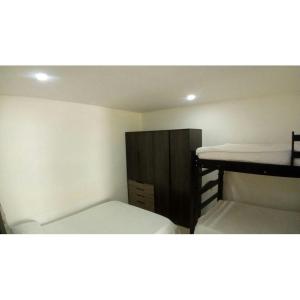 a small bedroom with two beds and a wooden cabinet at Holiday home in Gaira in Santa Marta +4 photos