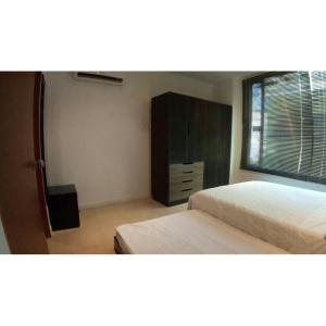 a bedroom with two beds and a dresser and a window at Holiday home in Gaira in Santa Marta