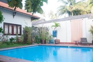 a swimming pool in front of a house at jardin des thes resort in Ấp Thiện Long