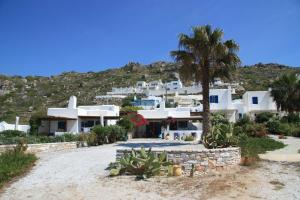 a group of white houses on a hill with a palm tree at Cozy house close to the beach in Plaka