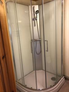 a shower with a glass door in a bathroom at Joarsbo, Stuga 1, Sjölyckan in Kalv