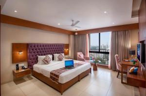 a bedroom with a bed with a laptop on it at SK Lords Inn Ahmedabad in Ahmedabad +61 photos