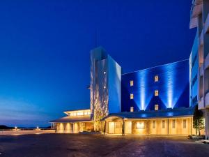 ein blaues Gebäude in der Nacht mit einem Gebäude in der Unterkunft Yukai Resort Premium Toba Saichoraku in Toba