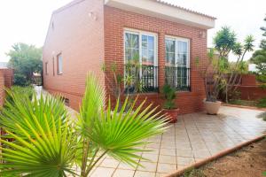una casa de ladrillo con plantas delante de ella en Luxury villa in Playa Honda, en Cartagena