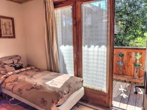 een slaapkamer met een bed naast een glazen schuifdeur bij Chalet Soleil in Landry