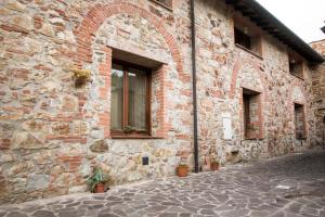 a brick building with a window and plants on it at Rustic Tuscan style apartment in Massa Marittima
