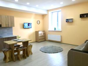 sala de estar con mesa y cocina en Абсолютно новая квартира-студия в ЖК Барский en Zarvantsy