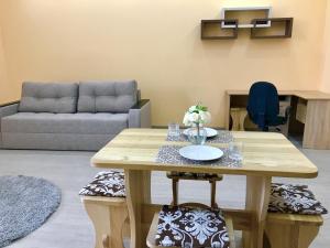 een woonkamer met een tafel en een bank bij Абсолютно новая квартира-студия в ЖК Барский in Khmelëva