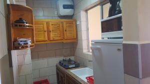 a small kitchen with wooden cabinets and a sink at Surfapartment Taghazout Nr 6 in Taghazout