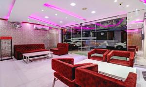 una sala d'attesa con sedie rosse e un tavolo di Treebo Trend Orion Sapphire a Ballygunge