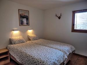 een slaapkamer met een bed en een raam bij Chalet Chamois in Landry