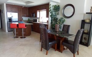 a kitchen with a wooden table and chairs and a mirror at Playa Bonita condo in Rosarito