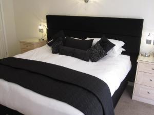 a black and white bed with black pillows on it at Druid House in Christchurch