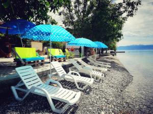 un grupo de sillas de césped y sombrillas en una playa en Villa Davor en Peštani
