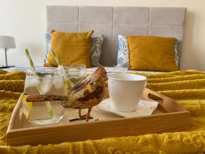 ein Tablett mit einem Vogel und Getränken auf dem Bett in der Unterkunft Sunrise Lighthouse Golf Private Villa in Baltschik