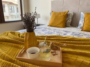 a tray of food and a vase on a bed at Sunrise Lighthouse Golf Private Villa in Balchik