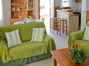 uma sala de estar com um sofá verde e uma mesa em Casa Louise - Great value 3 bedroom house in Son bou - Perfect for families em Son Bou