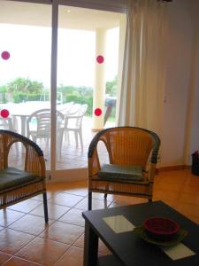 uma sala de estar com duas cadeiras e uma mesa em Casa Llebeig - Sensational Beautiful Property with sea views em Son Bou