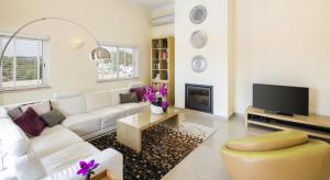 uma sala de estar com um sofá branco e uma televisão em Villa Povo do Burro beautiful and elegant villa few minutes walk to resort centre em Carvoeiro