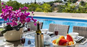 uma mesa com uma garrafa de vinho e uma taça de fruta em Villa Povo do Burro beautiful and elegant villa few minutes walk to resort centre em Carvoeiro