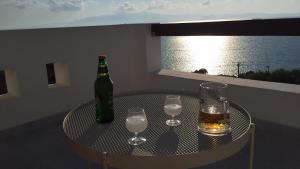 a table with a bottle and glasses on a balcony at Villa Irenes Dream - For dreamy holidays in Mikri Vigla