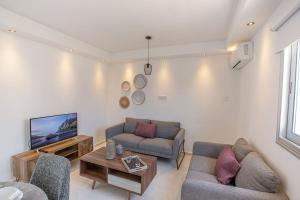 a living room with two couches and a tv at Apt Misia Enas - Modern 2 Bedroom Apartment with Sea Views - Close to Ayia Napa Square in Ayia Napa