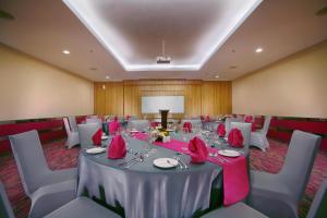 a banquet room with a table with pink table cloth at favehotel LTC Glodok in Jakarta